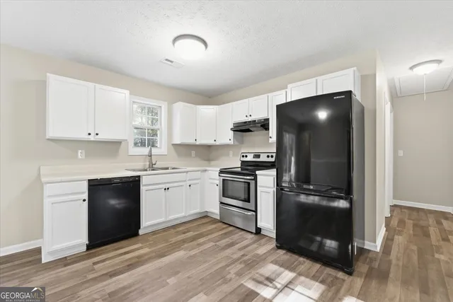 a kitchen with a refrigerator and a stove top oven