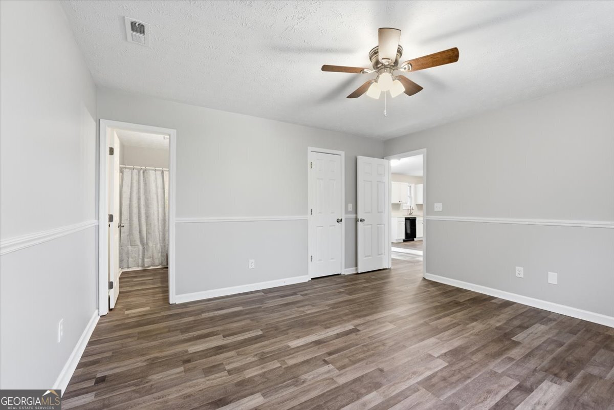 93 Robin Hood Road Covington, GA 30014 - Photo 8 of 20 an empty room with wooden floor ceiling fan and windows