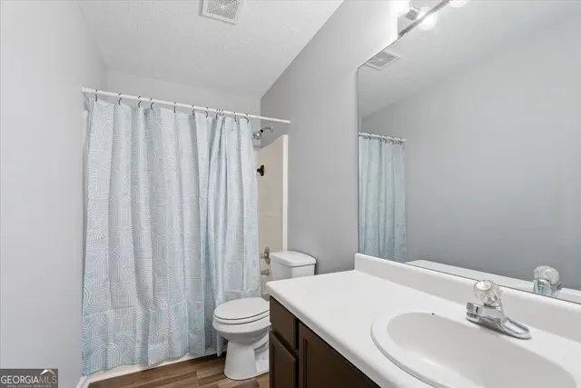a bathroom with a sink a toilet and shower curtain
