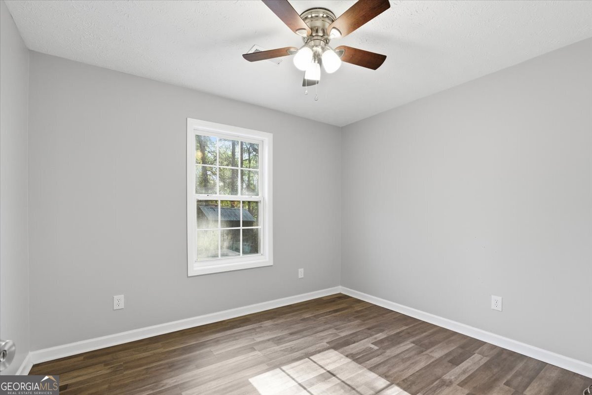93 Robin Hood Road Covington, GA 30014 - Photo 10 of 20 a view of an empty room with a window and wooden floor