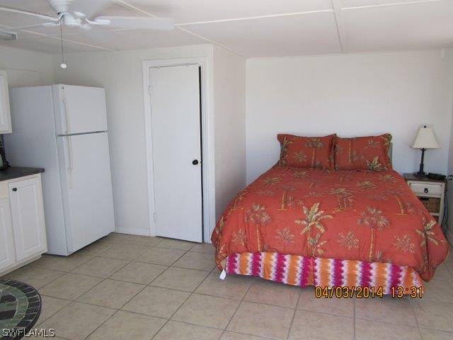 2606 Second Street Cape Coral, FL 33993 - Photo 16 of 24 a bedroom with a bed and a refrigerator
