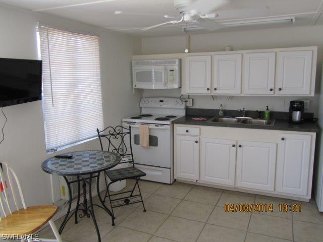 2606 Second Street Cape Coral, FL 33993 - Photo 17 of 24 a kitchen with granite countertop white cabinets and white appliances