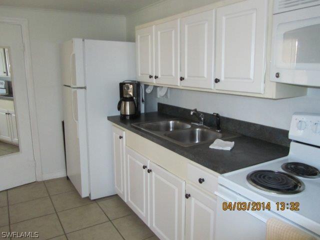 2606 Second Street Cape Coral, FL 33993 - Photo 20 of 24 a kitchen with stainless steel appliances granite countertop a sink a stove and a refrigerator