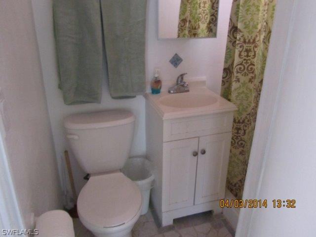 2606 Second Street Cape Coral, FL 33993 - Photo 21 of 24 a white toilet sitting next to a bathroom sink
