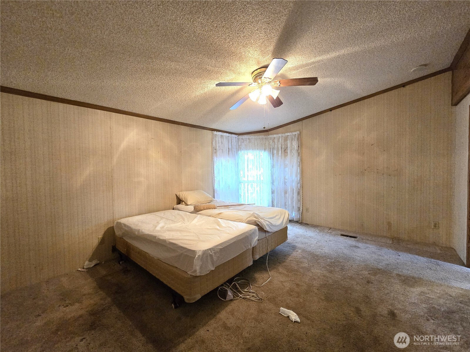520 North 3rd Street Elma, WA 98541 - Photo 7 of 28 a spacious bedroom with a bed and a chandelier