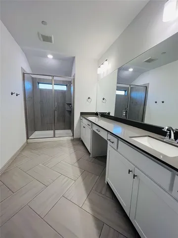 a large bathroom with a large mirror vanity and shower