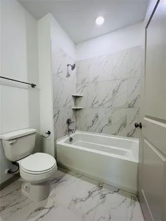 a bathroom with a toilet and a bathtub