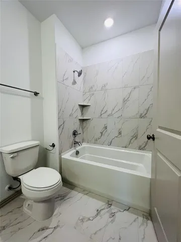 a bathroom with a toilet and a bathtub