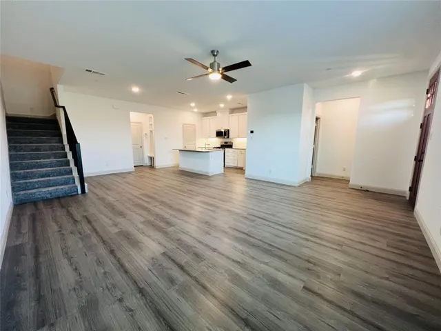 a view of a kitchen with wooden floor and a ceiling fan