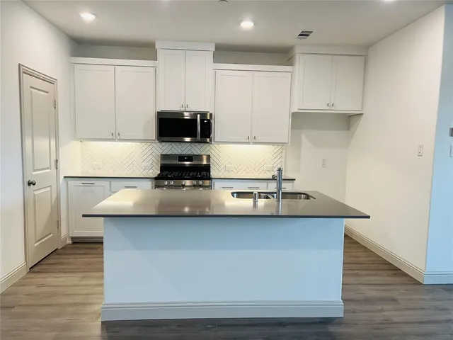 a kitchen with kitchen island stainless steel appliances a sink and refrigerator