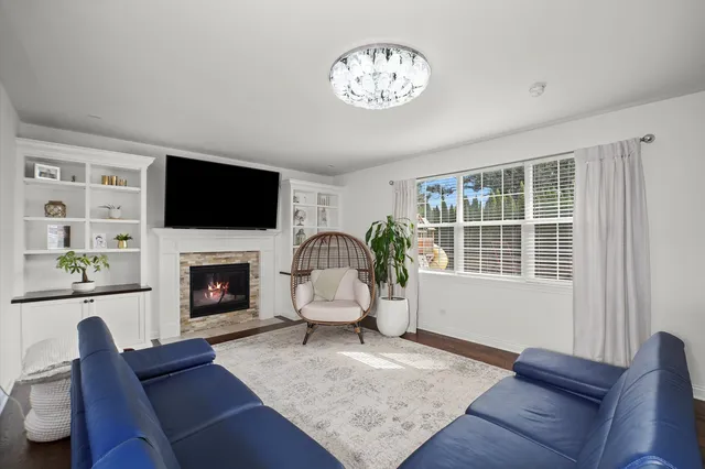 a living room with furniture a flat screen tv and a fireplace