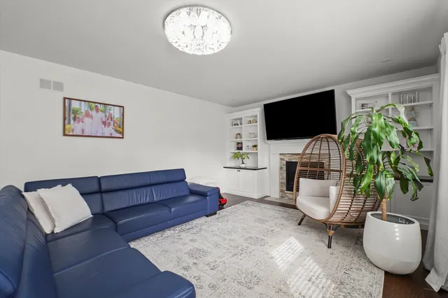 a living room with furniture a flat screen tv and a potted plant