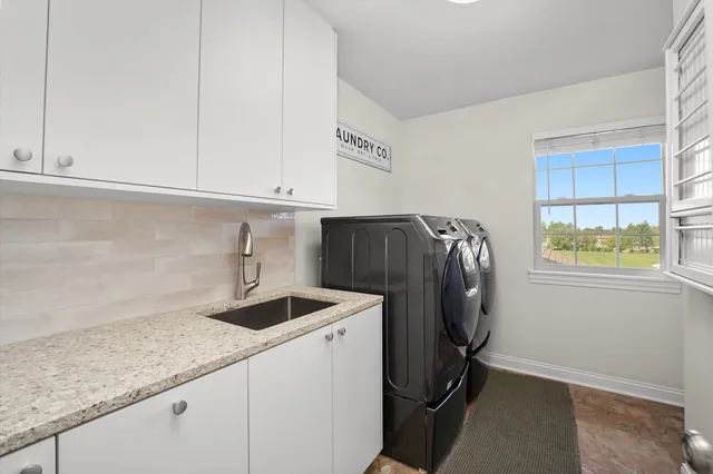 a utility room with sink dryer and washer
