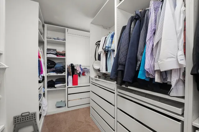 a view of walk in closet with clothes and shoes