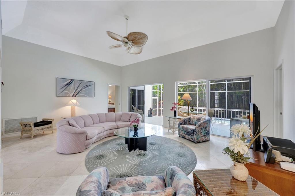 5929 Chanteclair Drive, Unit 8 Naples, FL 34108 - Photo 6 of 28 Living area featuring a ceiling fan, visible vents, light tile patterned floors, and a towering ceiling