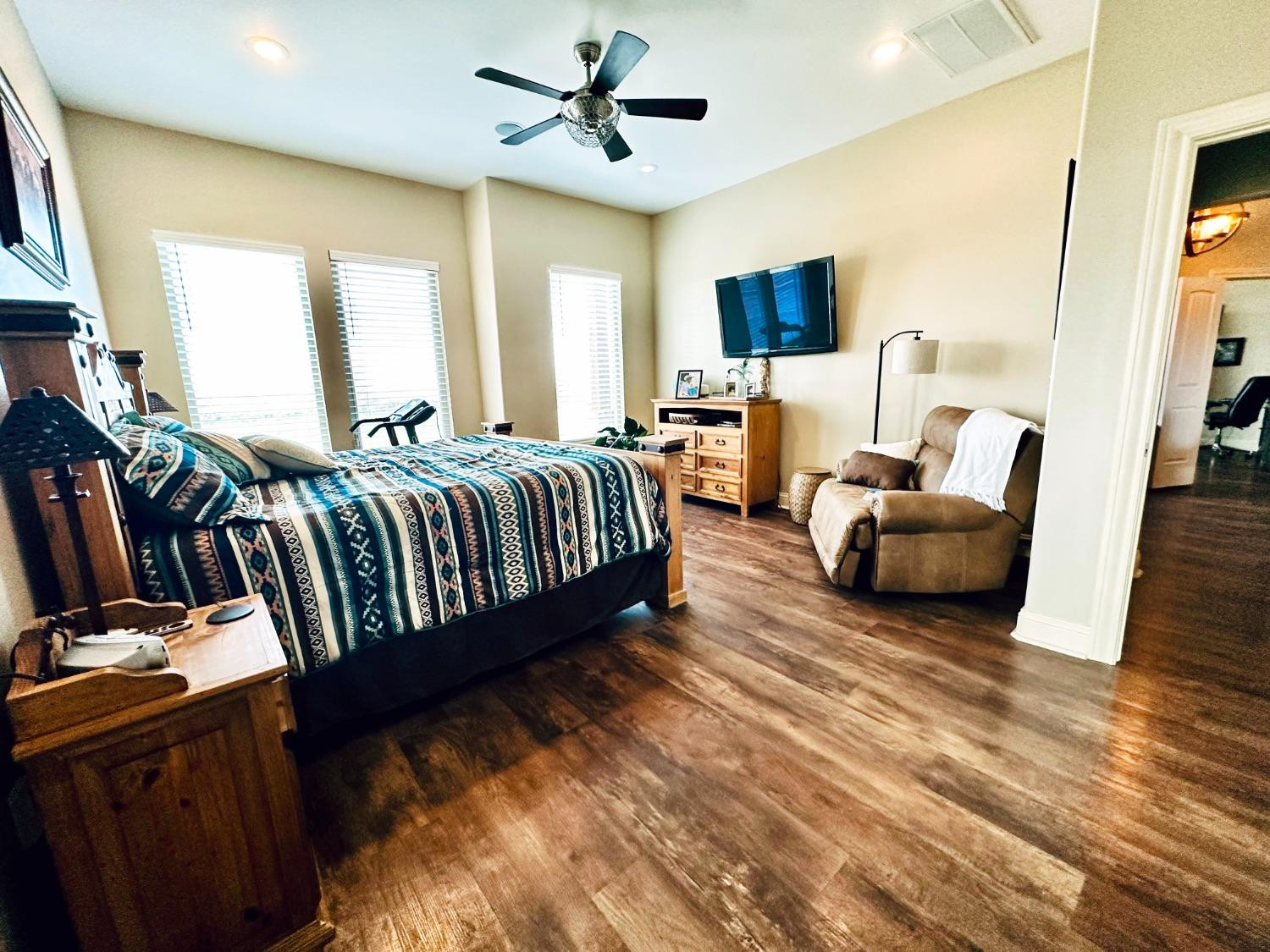 986 County Road 224 Post, TX 79356 - Photo 18 of 42 a spacious bedroom with a bed a couch and a flat tv screen on the dresser