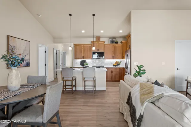 a living room with furniture kitchen view and a wooden floor