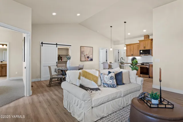 a living room with furniture and a view of kitchen