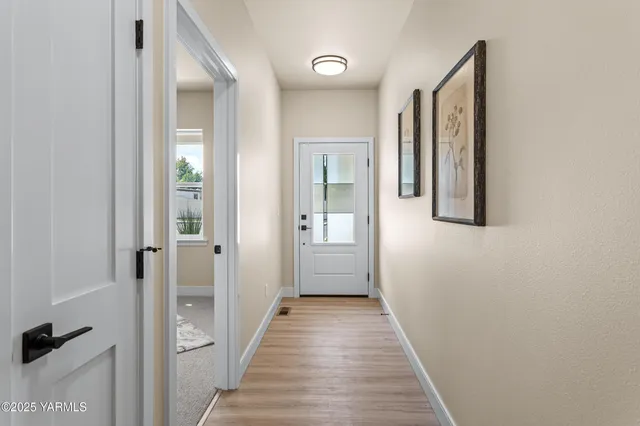 a view of a hallway with wooden floor and closet