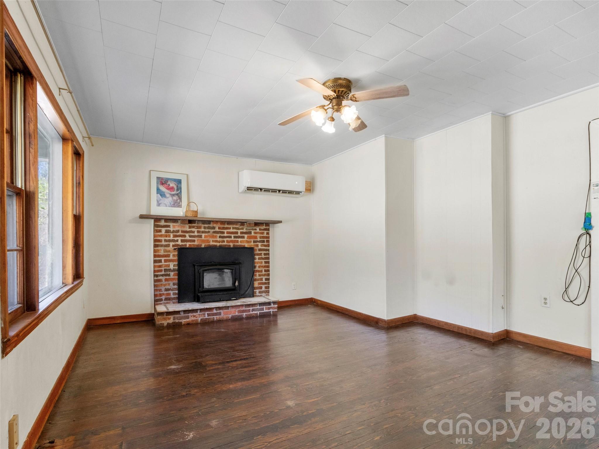 689 Bald Mountain Road Burnsville, NC 28714 - Photo 11 of 21 a view of a livingroom with a fireplace a ceiling fan and windows