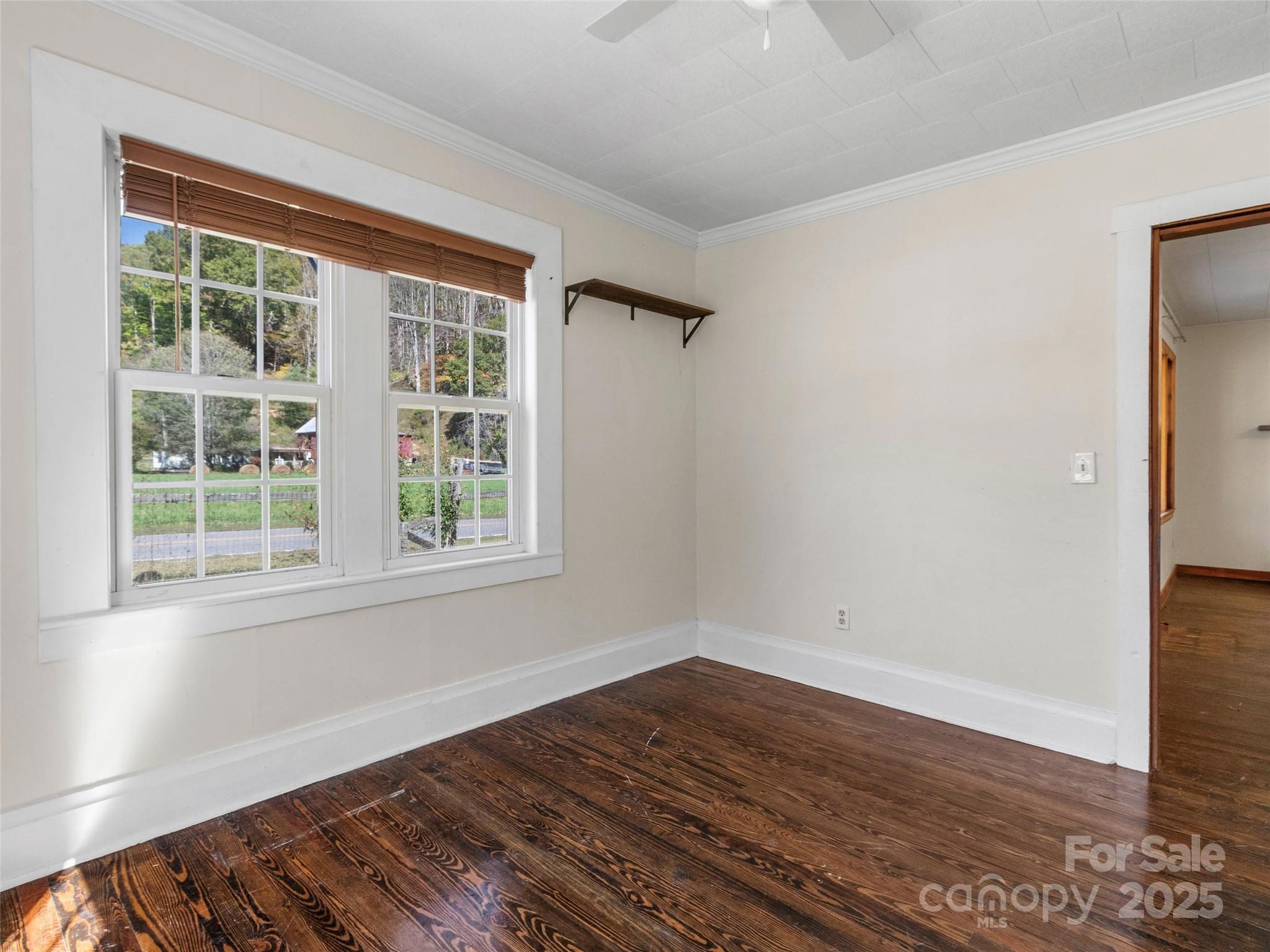 689 Bald Mountain Road Burnsville, NC 28714 - Photo 16 of 21 a view of an empty room with wooden floor and a window