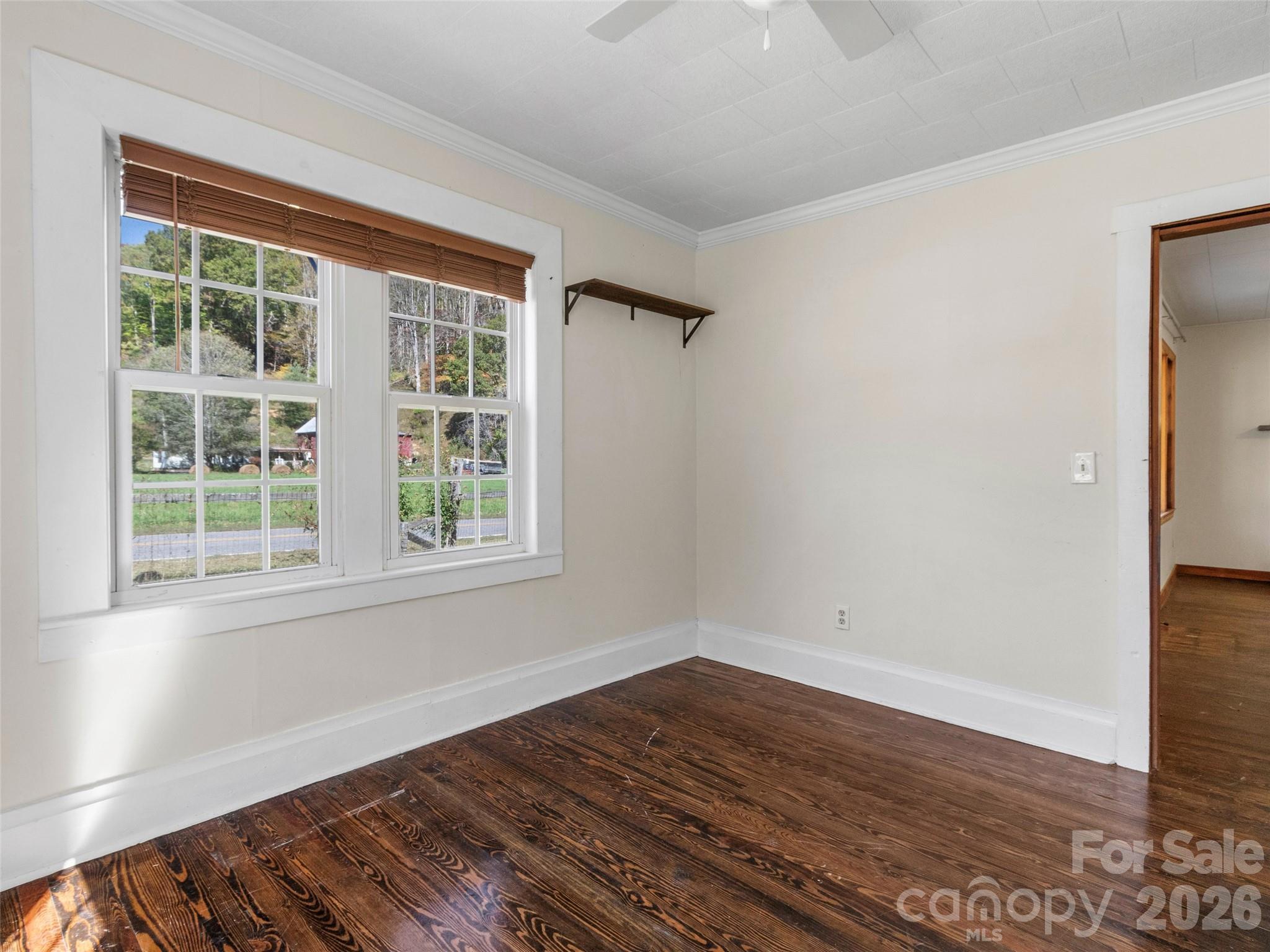 689 Bald Mountain Road Burnsville, NC 28714 - Photo 16 of 21 a view of an empty room with wooden floor and a window