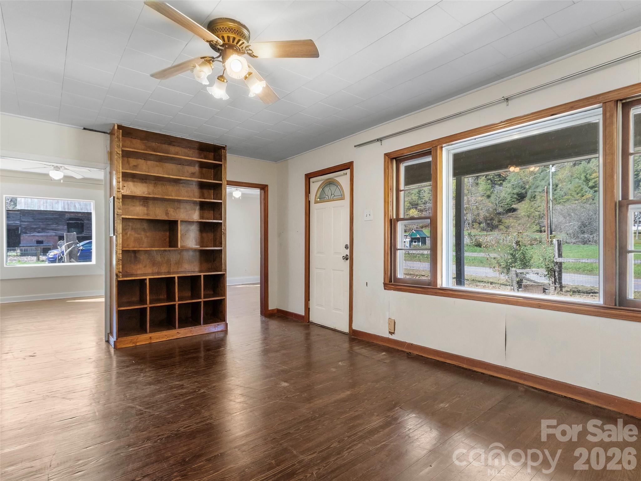 689 Bald Mountain Road Burnsville, NC 28714 - Photo 9 of 21 a view of an empty room with a window and wooden floor