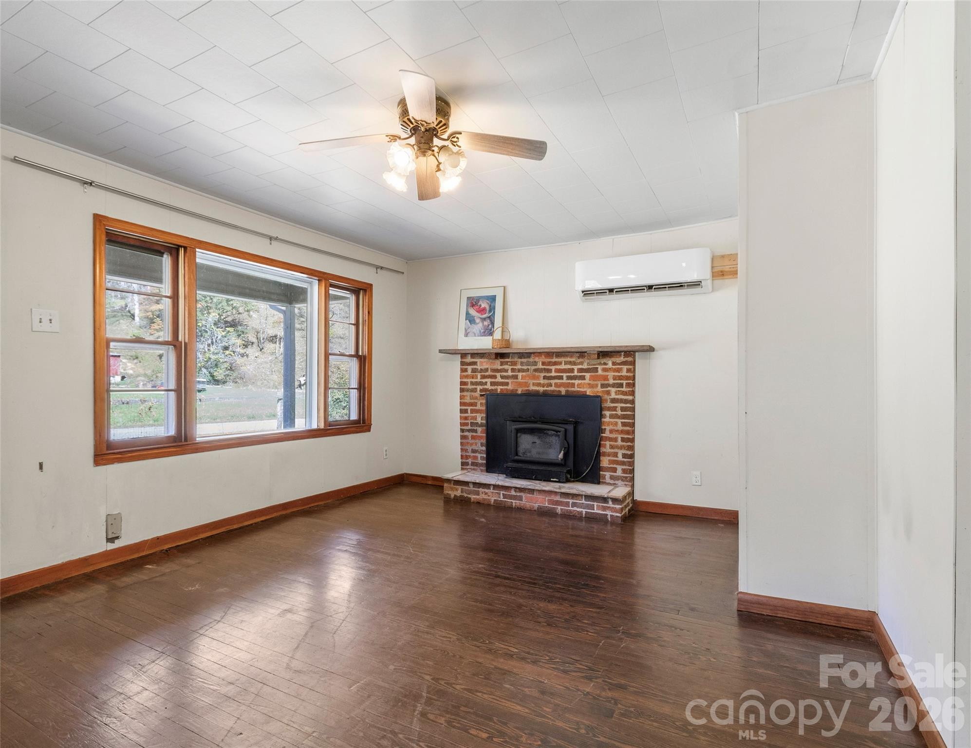 689 Bald Mountain Road Burnsville, NC 28714 - Photo 10 of 21 an empty room with windows fireplace and windows
