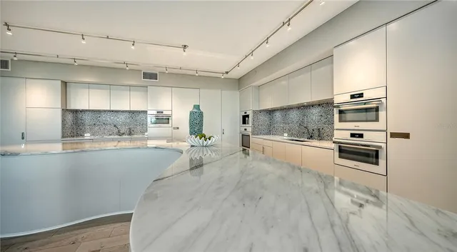 a large white kitchen with a stove a sink and dishwasher