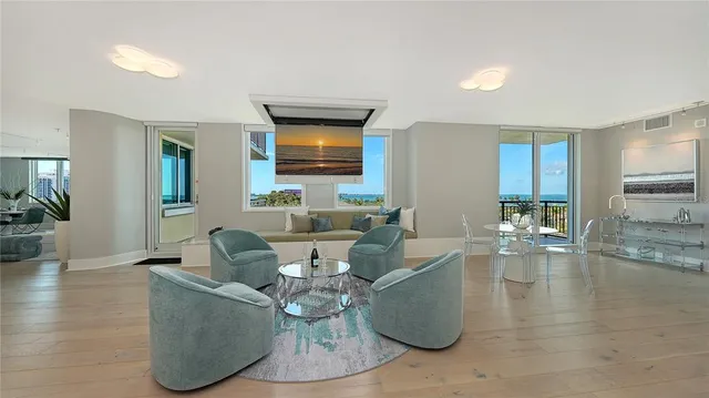 a living room with couches and a dining table with kitchen view