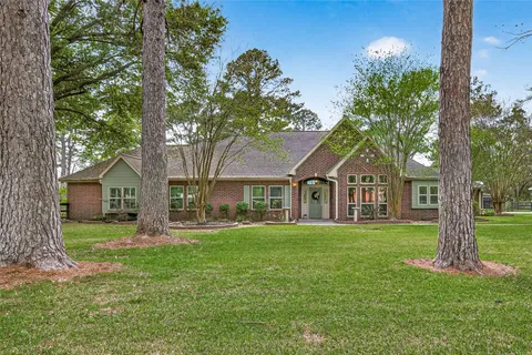 a front view of a house with a garden and trees