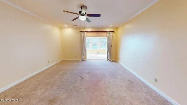 a view of a livingroom with a ceiling fan and window