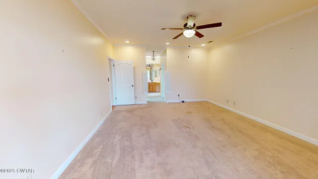 an empty room with a ceiling fan and a window