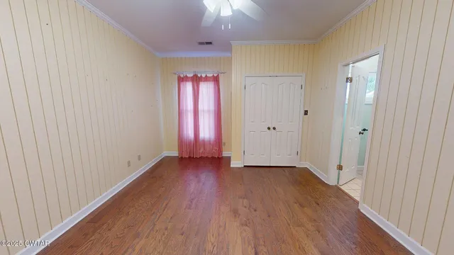 a view of an empty room with wooden floor