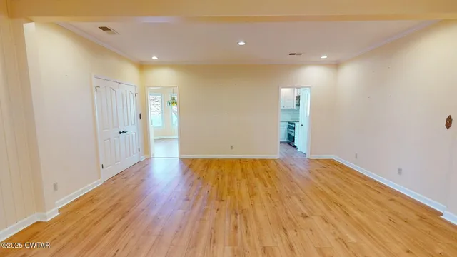 a view of empty room with wooden floor