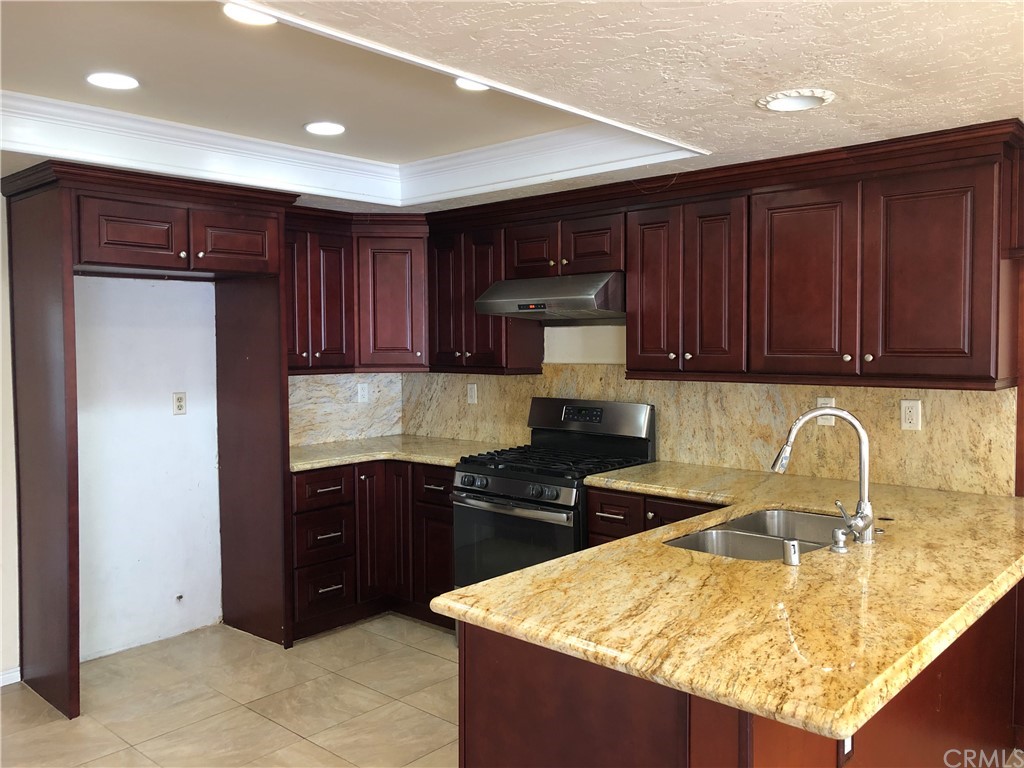 142 West Yale Loop Irvine, CA 92604 - Photo 12 of 28 a kitchen with kitchen island granite countertop a sink and cabinets