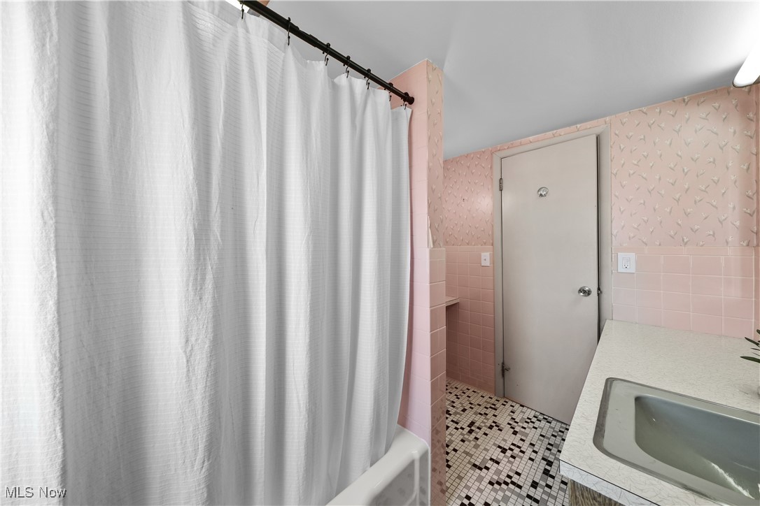 10078 Ellsworth Road Hudson, OH 44236 - Photo 12 of 34 Bathroom featuring shower / bath combo with shower curtain, sink, tile patterned flooring, and tile walls