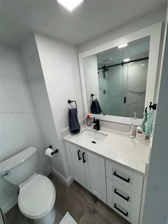 a bathroom with a toilet sink double vanity and mirror