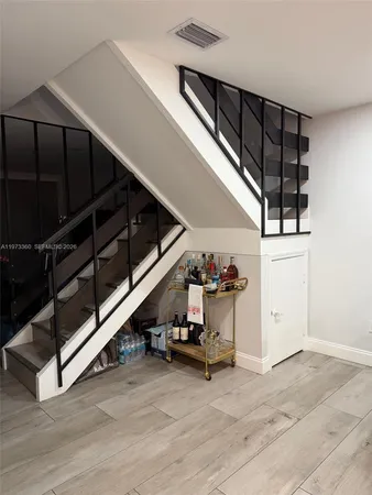a view of a hallway with wooden floor and white walls