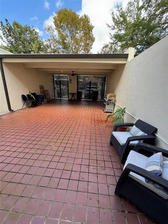 a backyard of a house with barbeque oven table and chairs