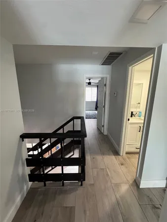 a view of a hallway with wooden floor and a furniture