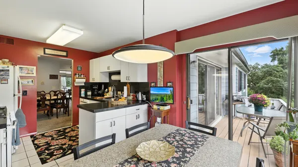 a kitchen with stainless steel appliances kitchen island granite countertop a stove a refrigerator and a dining table with the kitchen view