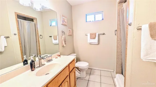 a bathroom with a sink a toilet and shower curtain