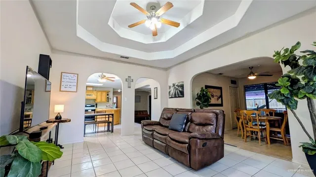 a living room with furniture a chandelier and a dining table
