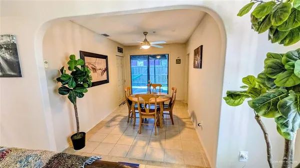 a dining room with furniture potted plants and wooden floor