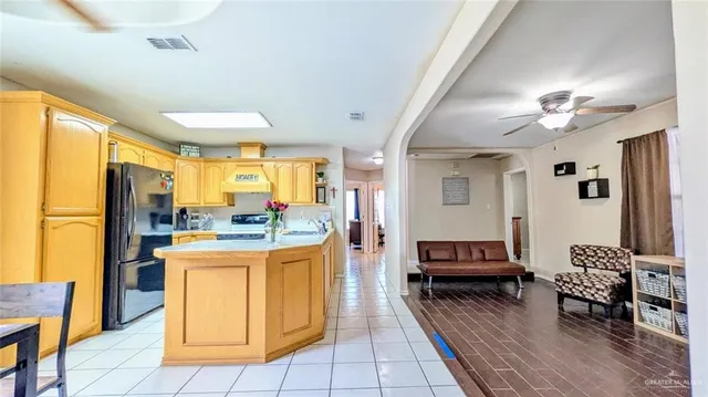 a living room with stainless steel appliances kitchen island granite countertop furniture and a rug