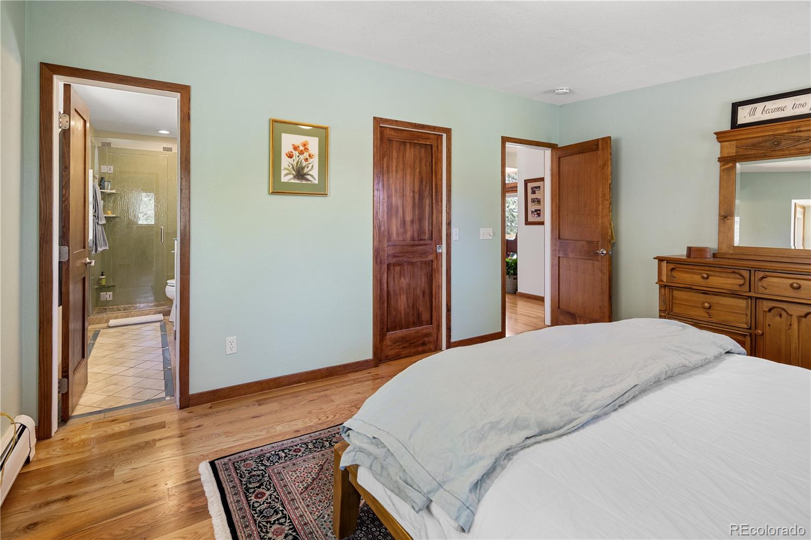 107 Elk Drive Evergreen, CO 80439 - Photo 22 of 45 a bedroom with a bed and wooden floor