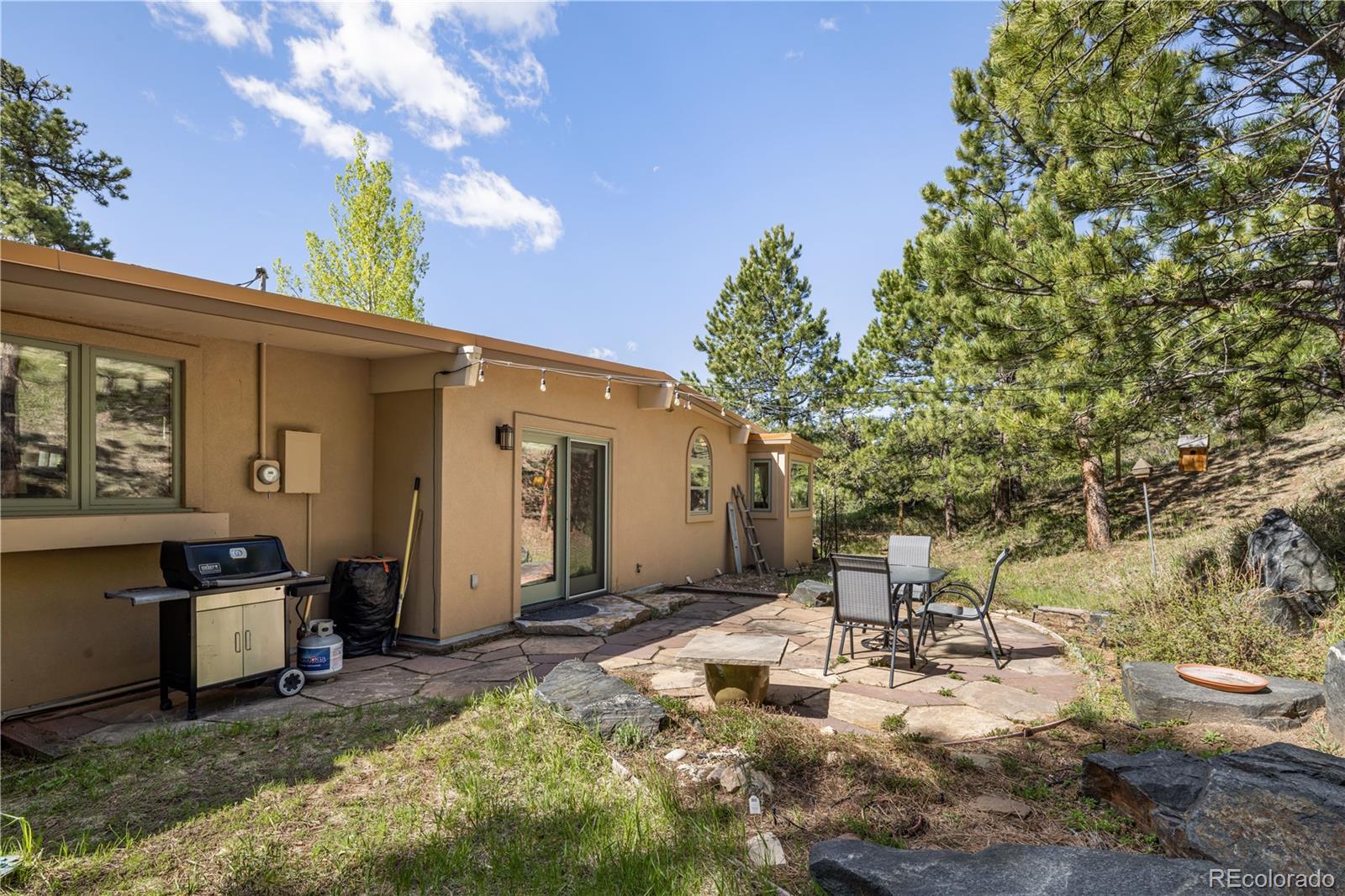 107 Elk Drive Evergreen, CO 80439 - Photo 37 of 45 a view of a patio with table and chairs and potted plants with wooden fence