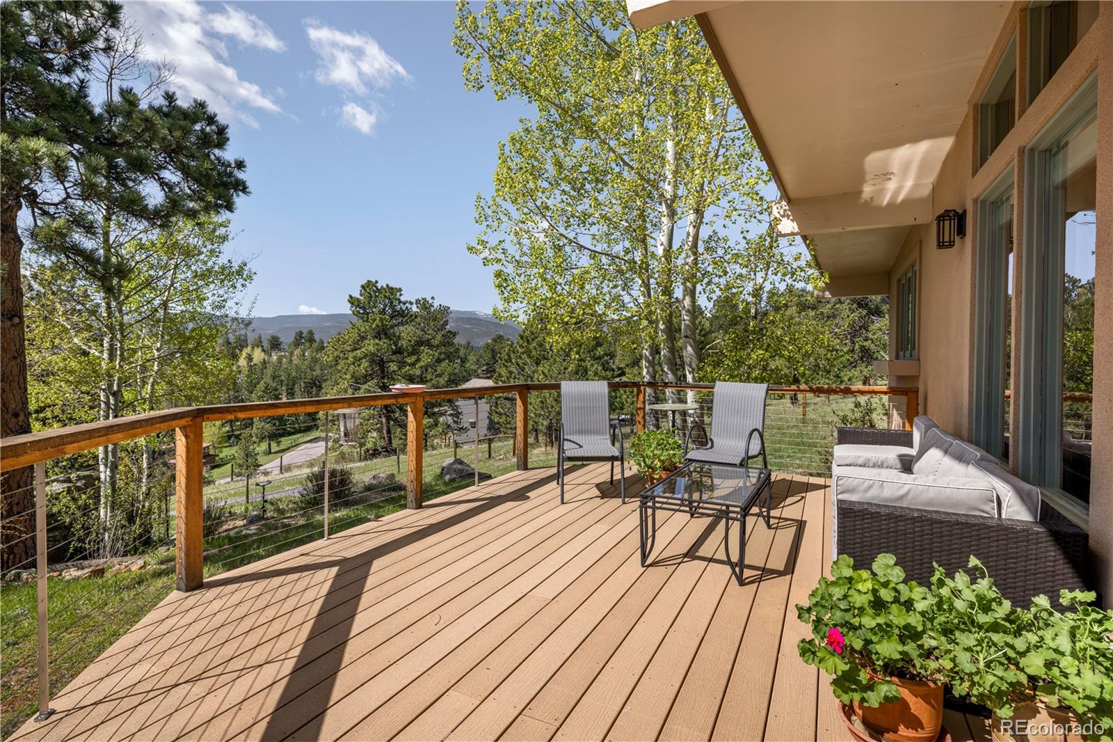 107 Elk Drive Evergreen, CO 80439 - Photo 10 of 45 a view of a chairs and table on the wooden deck