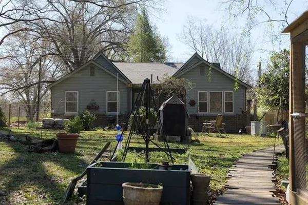 a view of house with backyard and outdoor seating